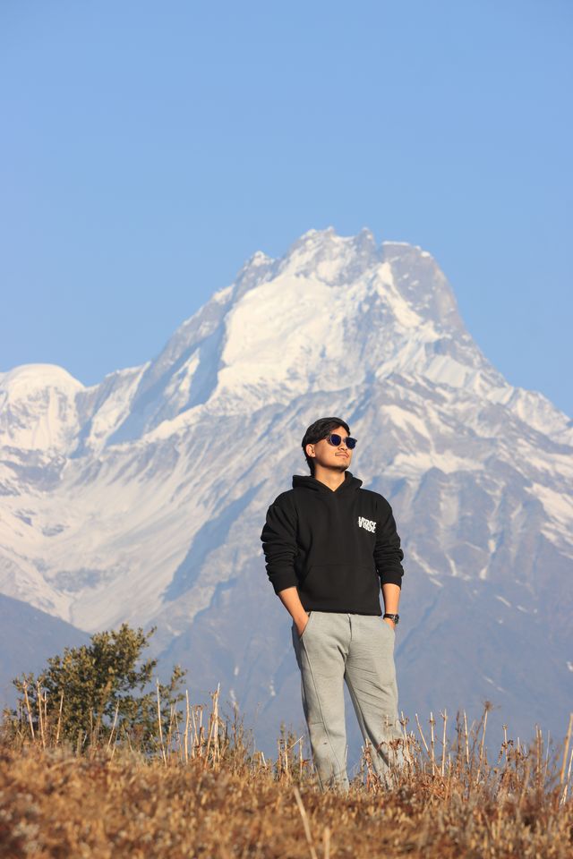 Aashish Rai on a trek in the Nepali Himalaya, with a snow peak behind him
